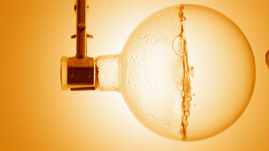 Orange hydrosol boiling in flask, condensation on glass walls