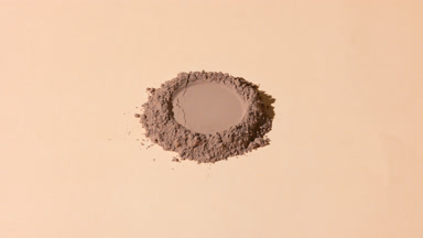 Vertical Arc Shot of Brown Powder with Round Imprint