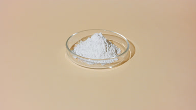 Curved Shot of White Powder in Petri Dish on Beige Tone