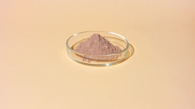 Fluid Shadows of Brown Powder in Glass Petri Dish