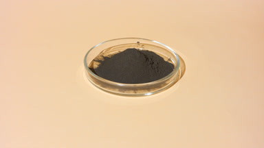 Black Clay Powder in Glass Dish with Changing Shadows