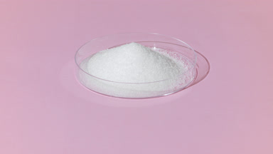 Orbiting Shot of White Powder in Petri Dish on Pale Pink
