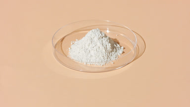 Tracking Shot of Fine White Powder in Petri Dish on Tan