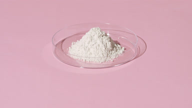 White Powder in Petri Dish on Pink Background with Light
