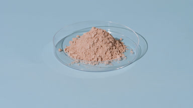 Beige Fine Powder in Petri Dish on Pale Blue Surface