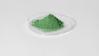 Green Fine Powder in Petri Dish with Rotating Light