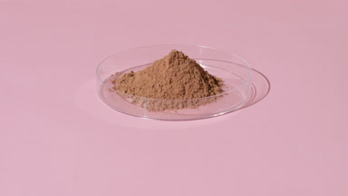 Dynamic Orbiting Light on Brown Powder in Petri Dish
