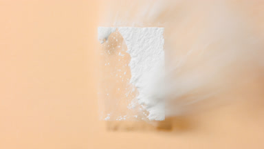 Slow-Motion White Powder Drift on Beige Background