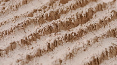 Beige Powder Surface with Orbiting Light and Shadows