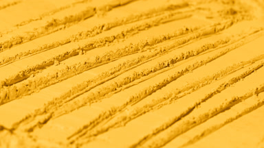 Fluid Shifting Shadows on Yellow Powder with Knife Trails