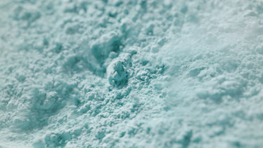 Tight Slow Motion Shot of Air Blown Cyan Powder