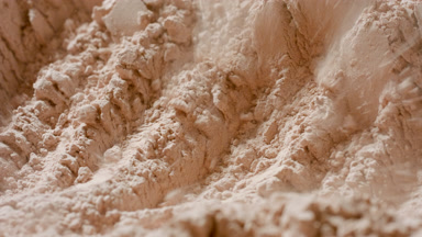 Beige Powder Surface Revealed in Macro Slow Motion