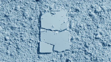 Cracked Powder on Pale Blue Surface with Light Effects