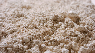 Close-Up of Disturbed Beige Powder Texture in Slow Motion