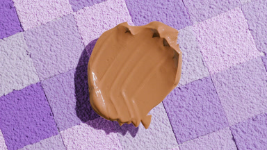 Extreme Close-Up of Dark Foundation on Violet Mosaic Surface