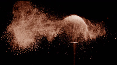 Macro Shot of Black Brush Flicking Beige Powder