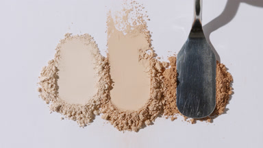 Three Beige Powder Heaps on Grey Background