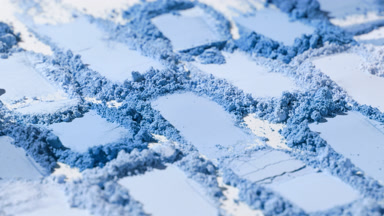Extreme Close-Up of Blue Powder Heaps on Pale Grey