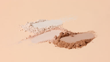 Extreme Close-Up of Beige Powder Streaks with Rotating Light