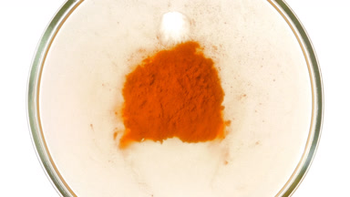 Orange Dust Cloud in Petri Dish on Smooth White Surface