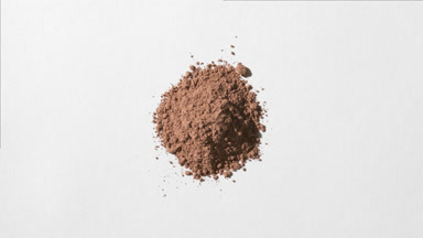 Brown Powder on Dim Grey Background with Shifting Shadows