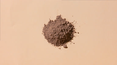 Heap of Brown Powder on Beige with Shifting Shadows