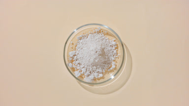 Top-Down View of Beige Powder in Glass Dish