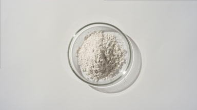 Overhead View of White Powder in Petri Dish on Grey Background