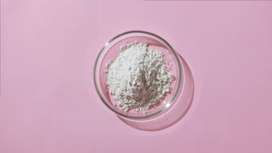 Heap of White Powder in Petri Dish on Pastel Pink Surface