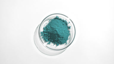 Cyan Powder in Petri Dish with Fluid Shadows