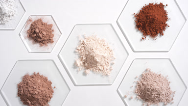 Top View of Beige and Brown Powders on Light Grey Glass