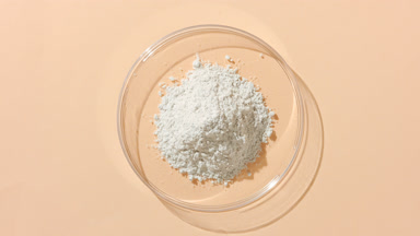 Overhead View of Fine White Powder in Petri Dish on Tan