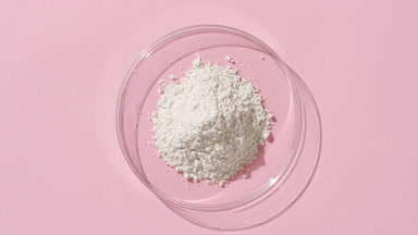 Top-Down View of Fine Powder in Petri Dish on Pink