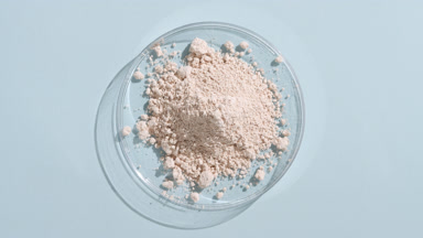 Light Beige Powder in Petri Dish on Pastel Blue with Light