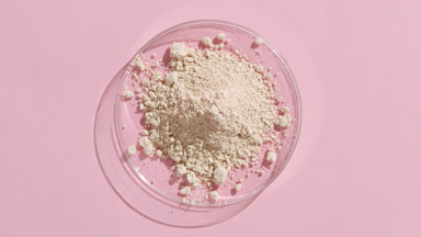 Light Beige Powder in Petri Dish on Pale Pink Canvas with Light