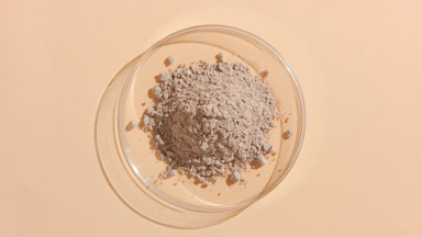 Beige Fine Powder in Petri Dish on Beige Backdrop