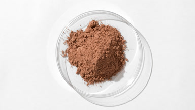 Brown Fine Powder in Petri Dish on Light Grey Background
