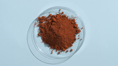 Brown Powder Stack in Shallow Dish with Blue Background