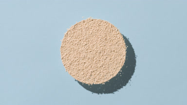 Beige Powder Circle Casting Shadows on Faint Blue for Foundation