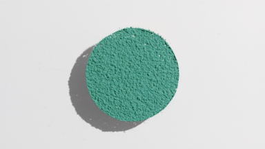 Cyan Powder Sifting with Dynamic Shadows on Gray Surface