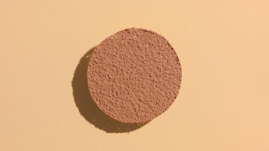 Brown Powder Sifting on Transparent Surface with Shadows