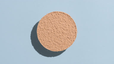 Skintone Powder Casting Shadow on Pastel Blue Surface