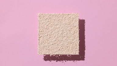 Shifting Shadows of Beige Powder on Pastel Pink Background