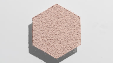 Shifting Shadows of Hexagonal Beige Powder on Grey Background
