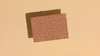 Brown Powder Rectangle with Shadow on Sand-Colored Surface