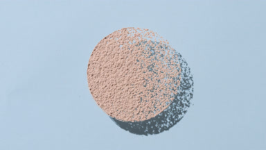 Beige Powder Round Shape Creating Shadows on Blue Background
