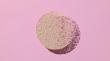 Beige Powder Circle Casting Shadow on Pale Pink Canvas