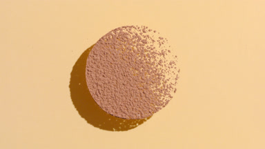 Circular Brown Powder Casting Shadows on Pastel Pink