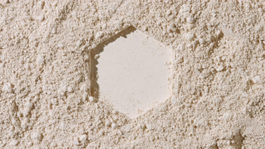 Beige Powder Surface with Hexagonal Imprint and Shadows