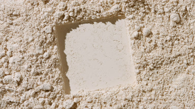 Shifting Shadows on Beige Powder Surface with Square Imprint